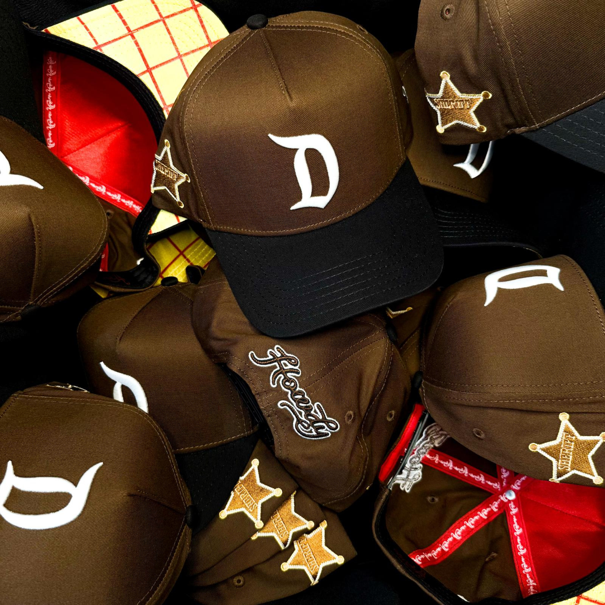 Collection of brown caps with various designs and logos on a checkered background
